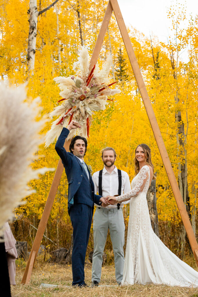 Lucky Penny Events event planner fall weddings dried florals groom raising hand in the air bride smiling at the altar Crested Butte photographer Gunnison photographers Colorado photography - proposal engagement elopement wedding venue - photo by Mountain Magic Media