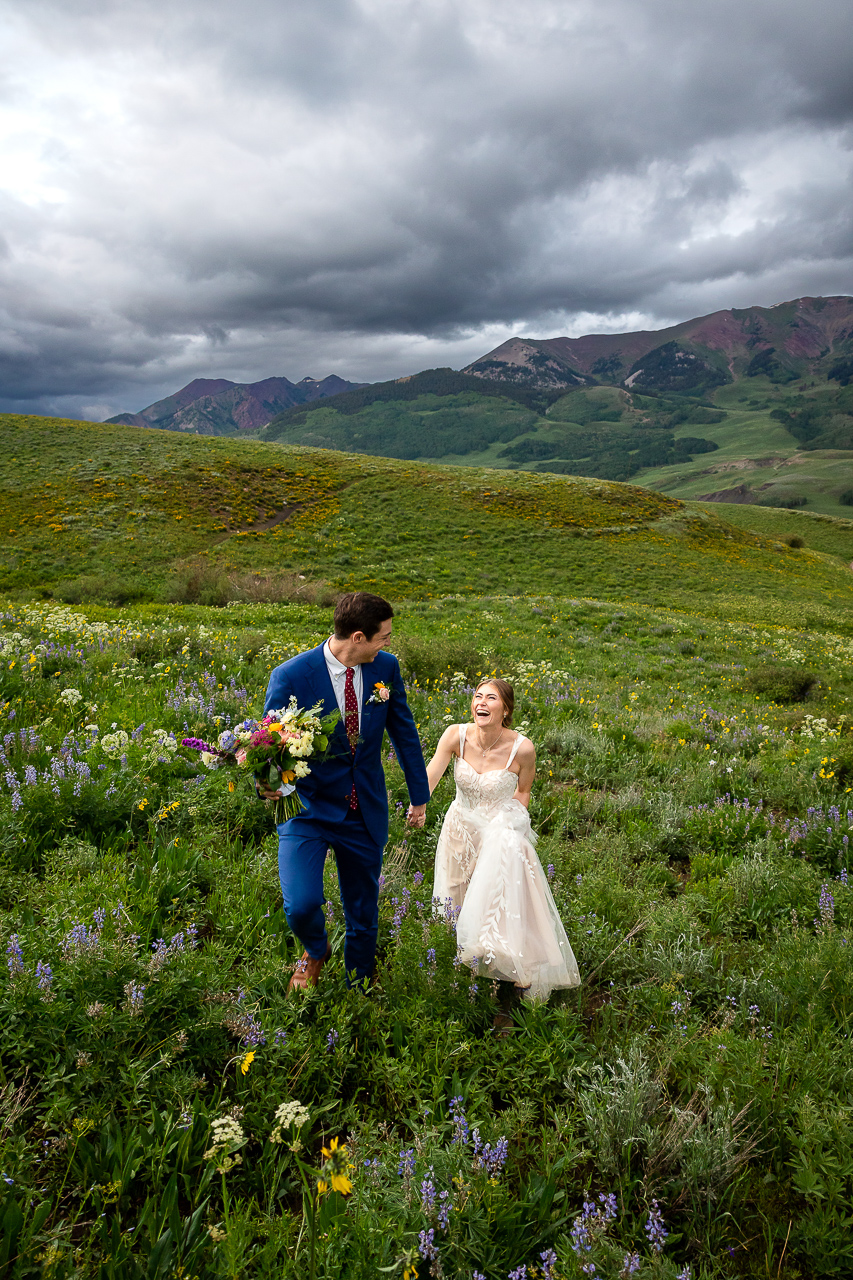 laughing leading newlywed couple hand in hand adventurous love story Crested Butte photographer Gunnison photographers Colorado photography - proposal engagement elopement wedding venue - photo by Mountain Magic Media