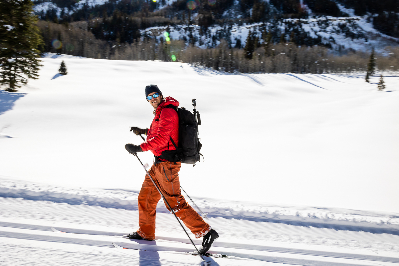 holding camera backpack bag while skiing on mountain photoshoot Crested Butte photographer Gunnison photographers Colorado photography - proposal engagement elopement wedding venue - photo by Mountain Magic Media