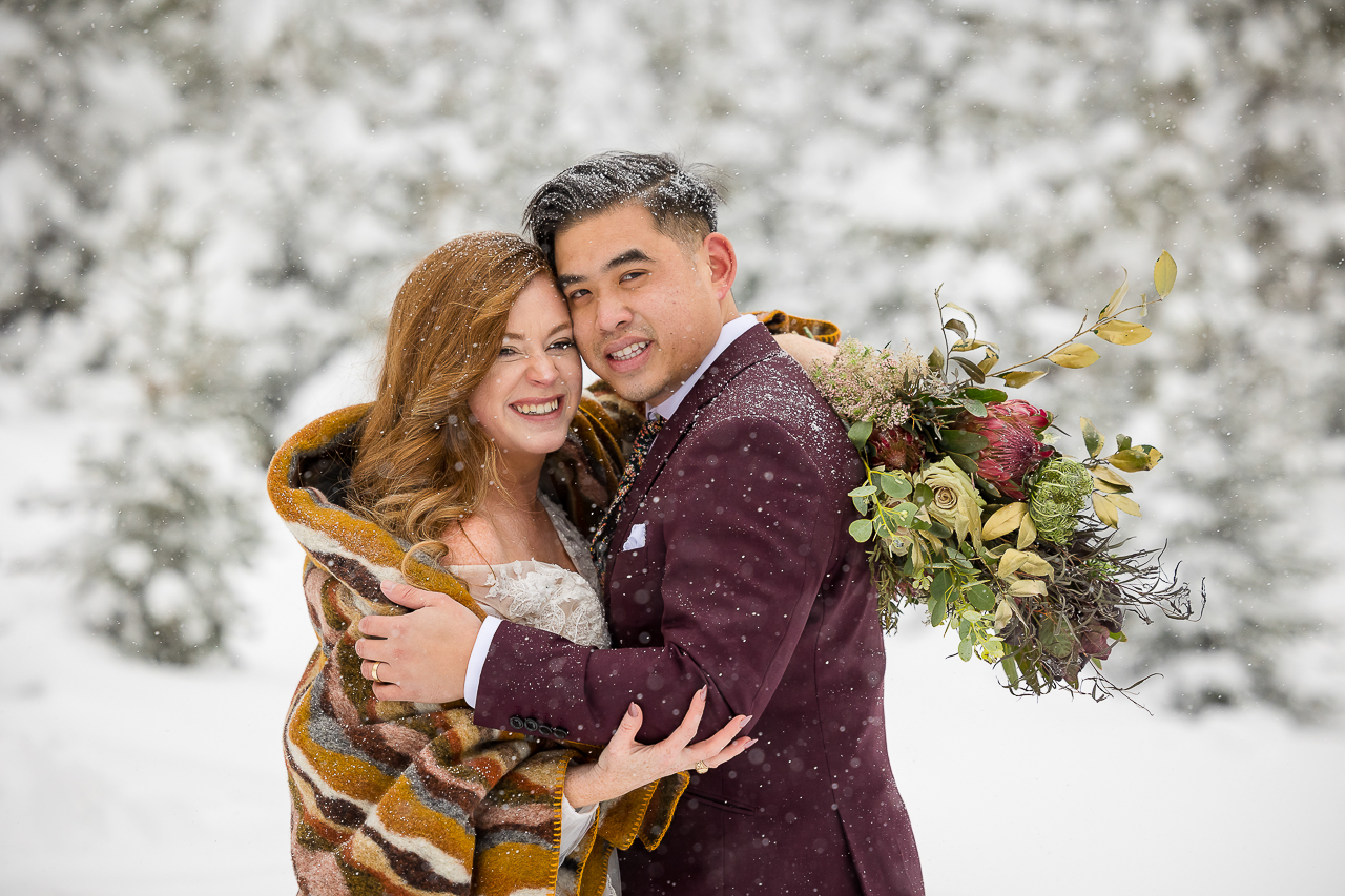snowy smiling couple newlyweds wrapped in blanket snow scene winter elope Aspen Crested Butte photographer Gunnison photographers Colorado photography - proposal engagement elopement wedding venue - photo by Mountain Magic Media