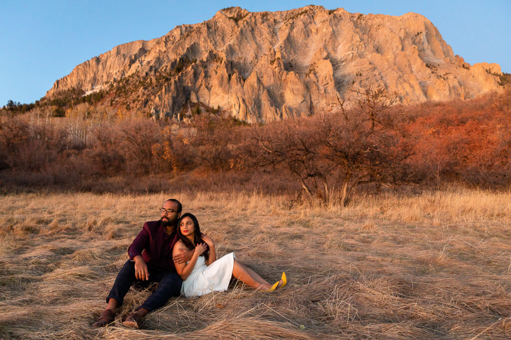 couple sitting in front of a mountain watching the sunset in Crested Butte