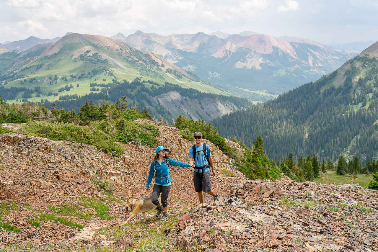 couple hiking in mountains with dog Crested Butte photographer Gunnison photographers Colorado photography - proposal engagement elopement wedding venue - photo by Mountain Magic Media