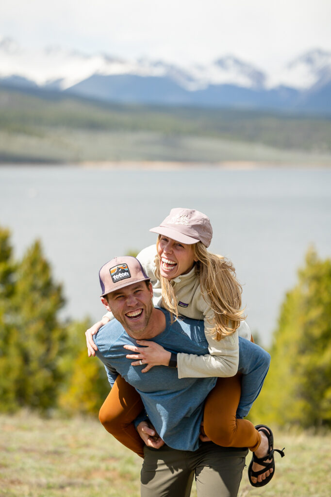 couple piggyback with lake in background mountains with dog Crested Butte photographer Gunnison photographers Colorado photography - proposal engagement elopement wedding venue - photo by Mountain Magic Media