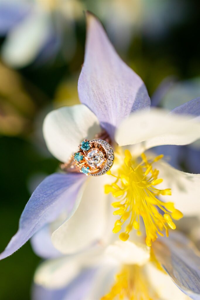 Details of an engagement ring resting on a white flower