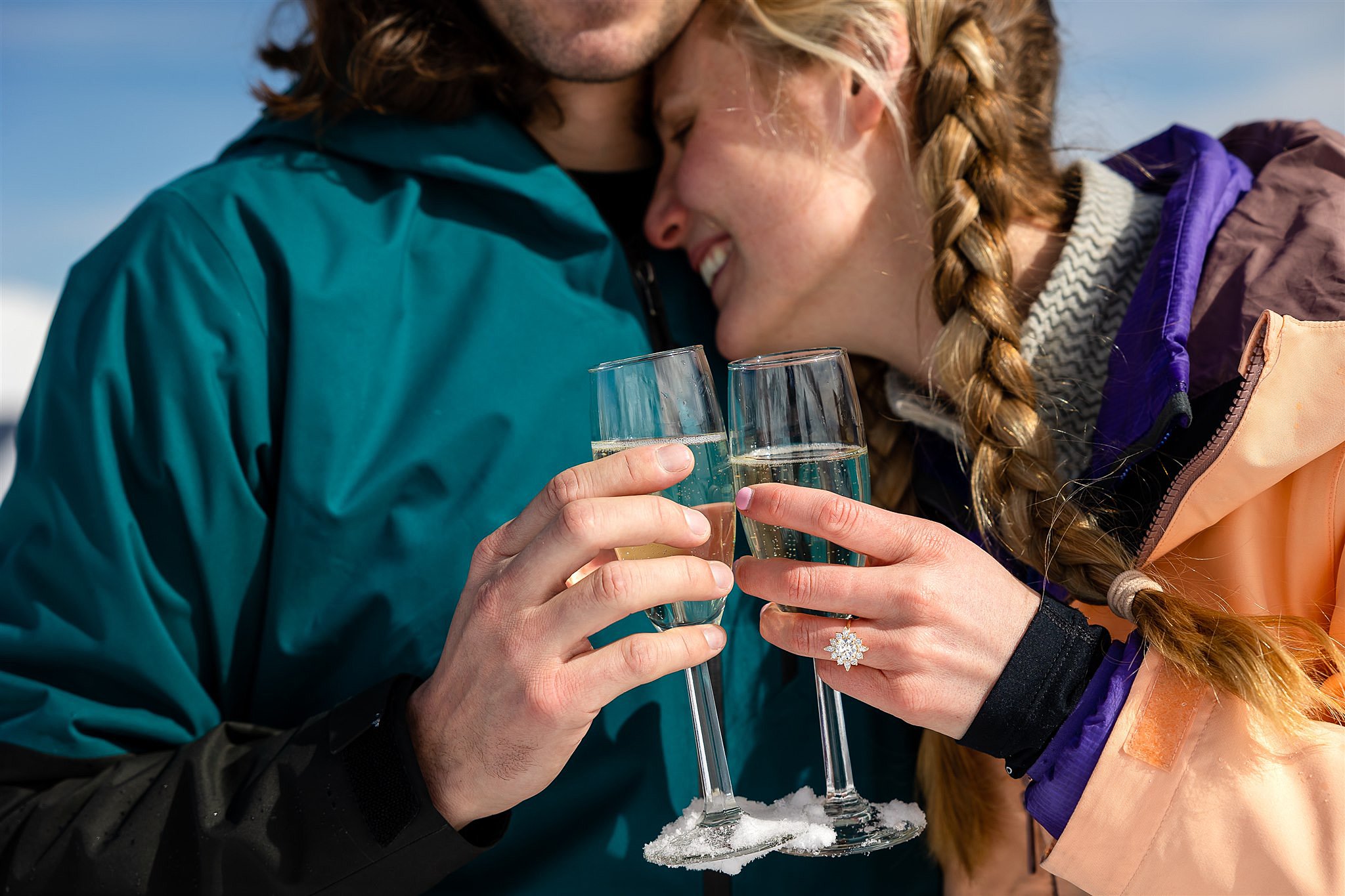 Details of A Newly Engaged Couple toasting champagne glasses with a flower ring on her finger Colorado Proposal Photographer