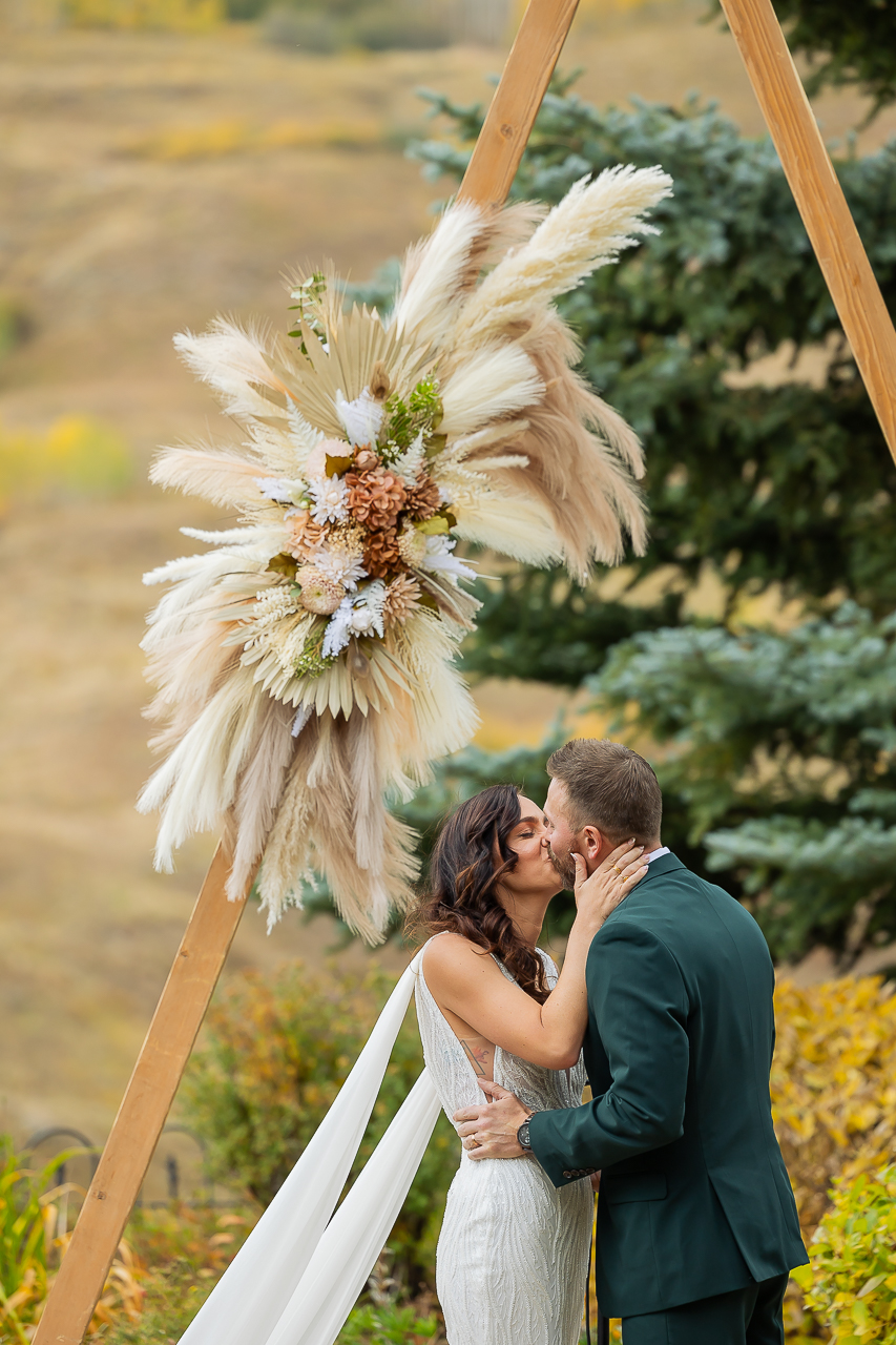 first kiss newlyweds couple just married wedding day Mountain Wedding Garden Crested Butte florals by Fin + Ally florist, plus planning and rentals by Lucky Penny Events