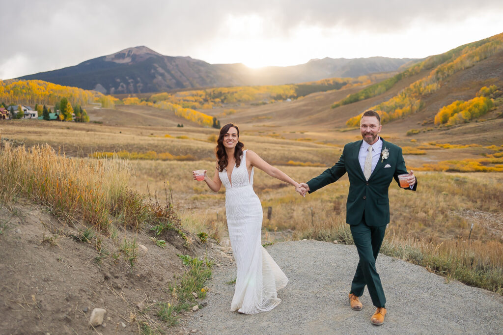 newlyweds celebrating with cocktails in hand during sunset at one of the Best Crested Butte Weddings Venues, the Mountain Wedding Garden