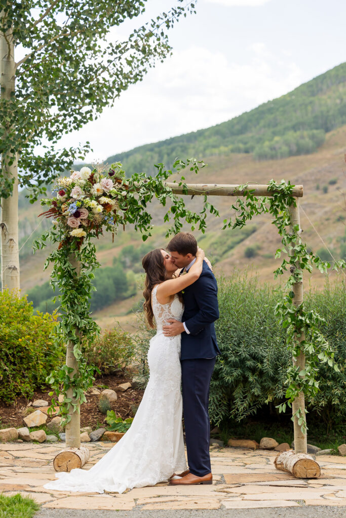 first kiss newlyweds married couple kissing at the altar at the Mountain Wedding Garden venue in Mount Crested Butte