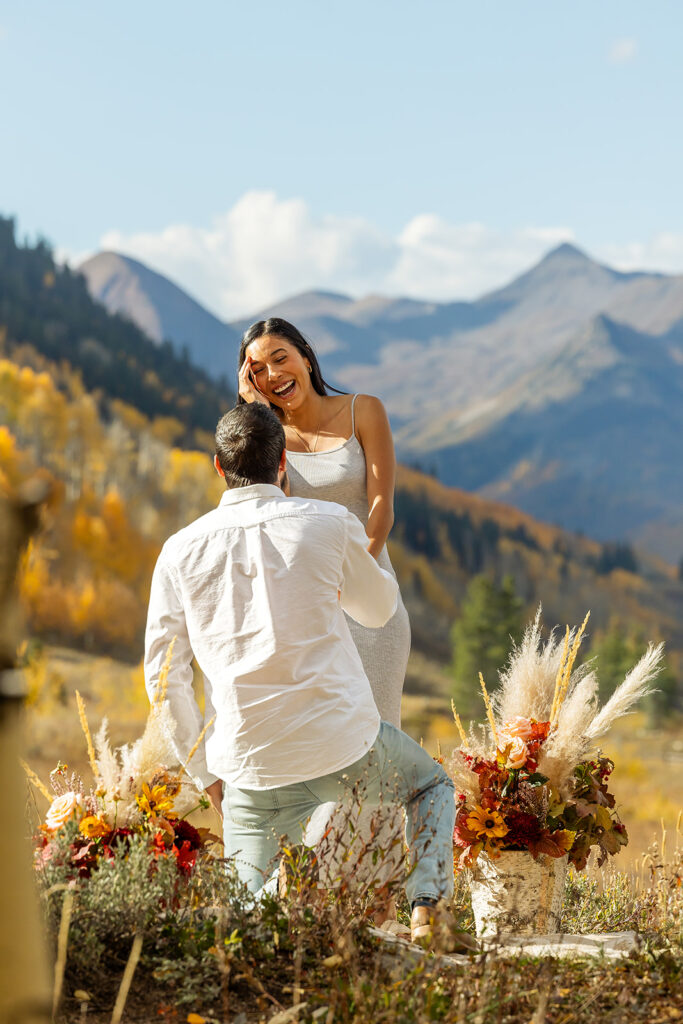 surprise proposal reaction with fall floral arrangements and mountain backdrop in crested butte colorado