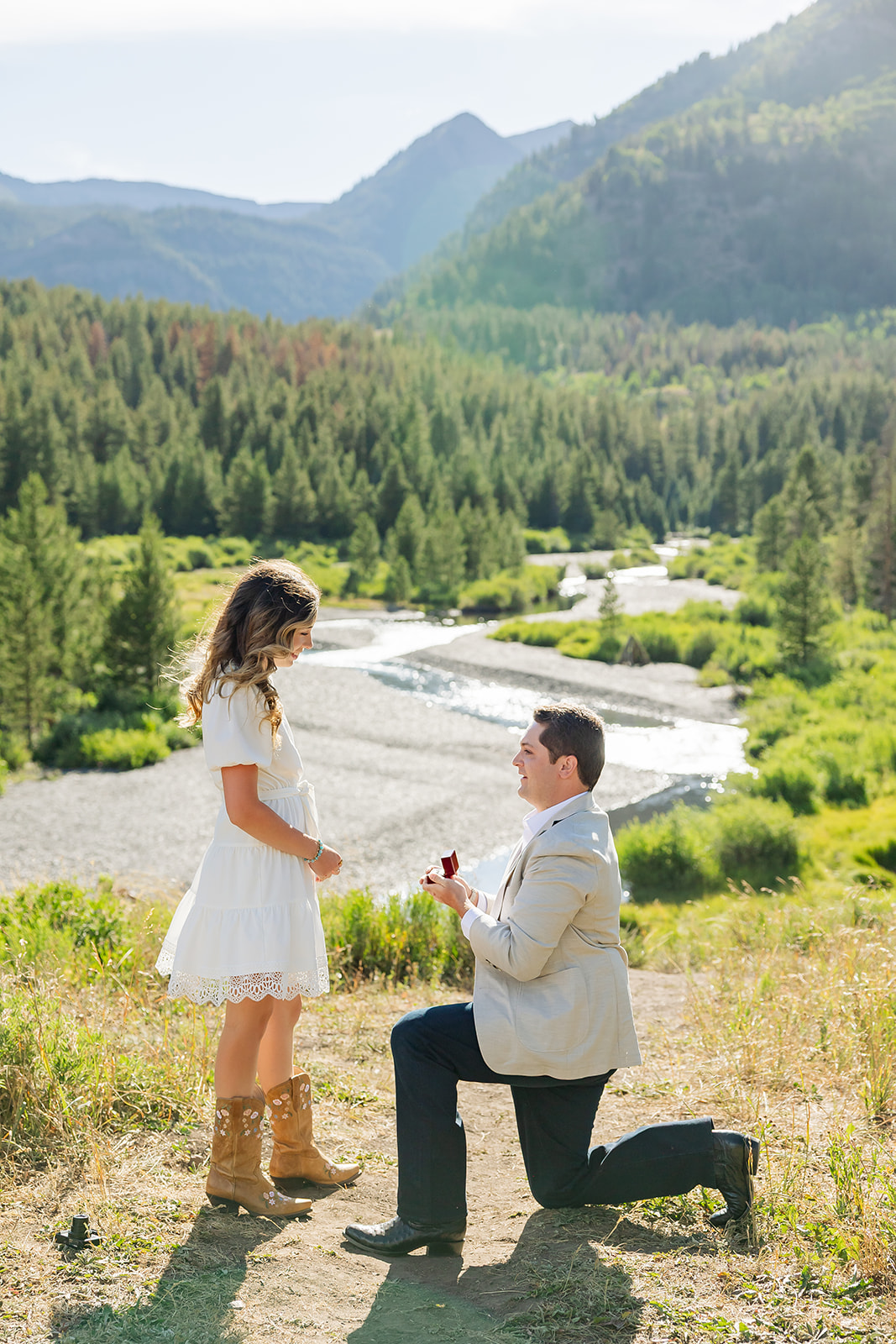 mountain view proposal man on his knee with woman surprised summer surprise proposals engagement in Crested Butte Colorado proposal photographer planner