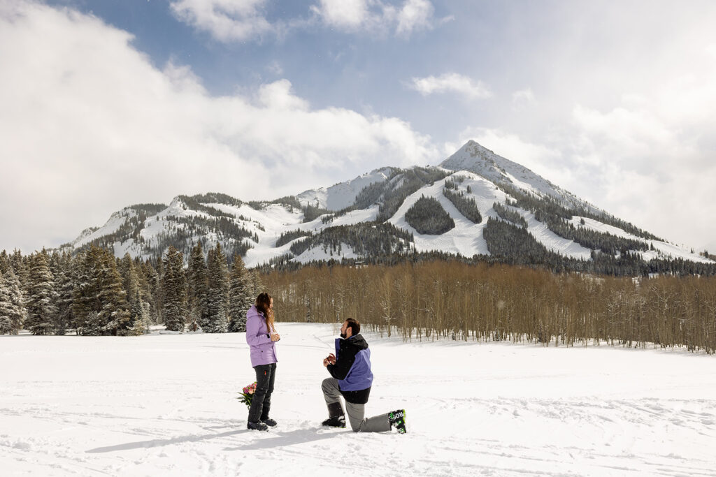 man proposing to woman in Crested Butte with winter mountain views Proposal Packages